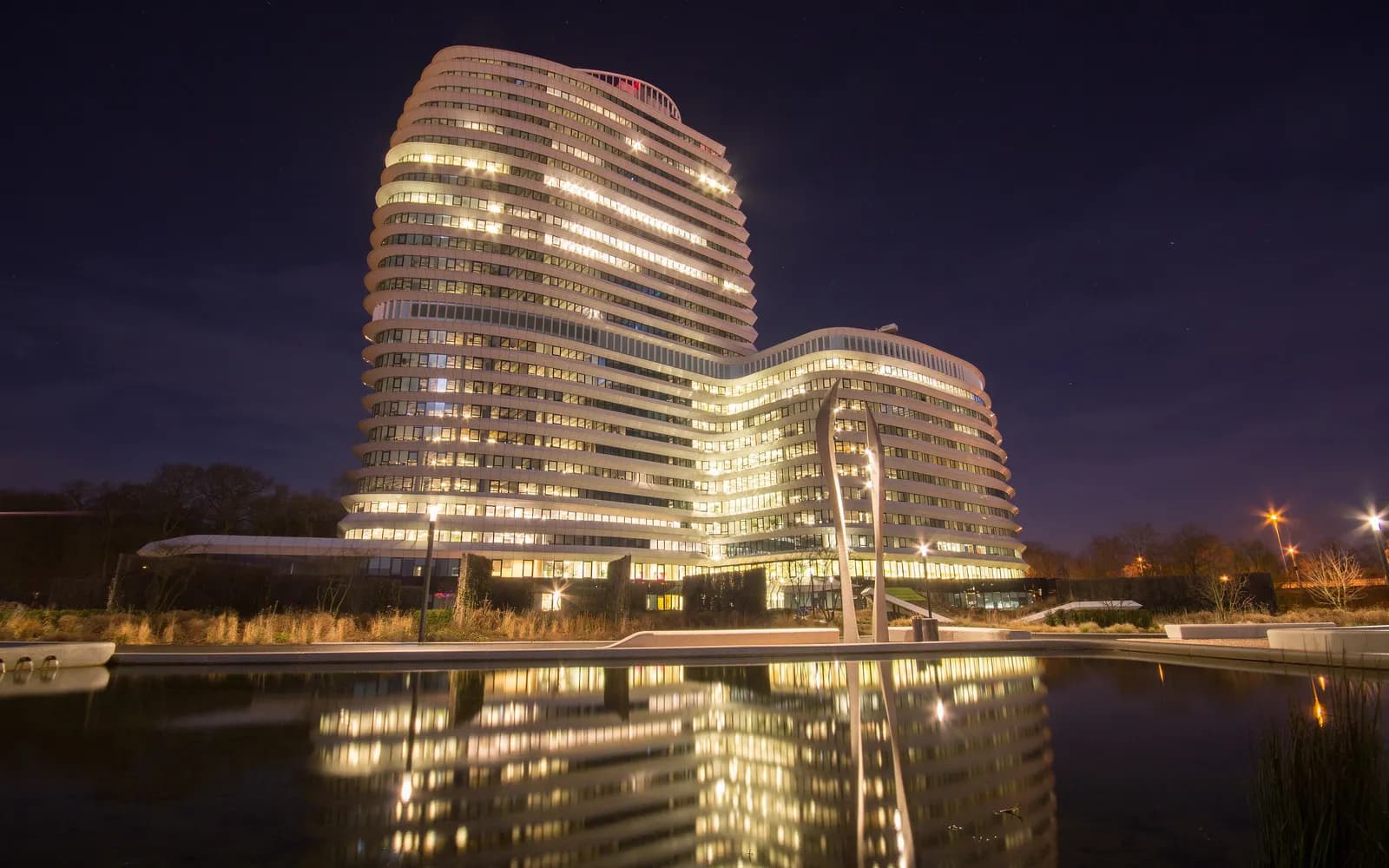 Modern kantoorgebouw aan het water in Groningen, verlicht bij avond