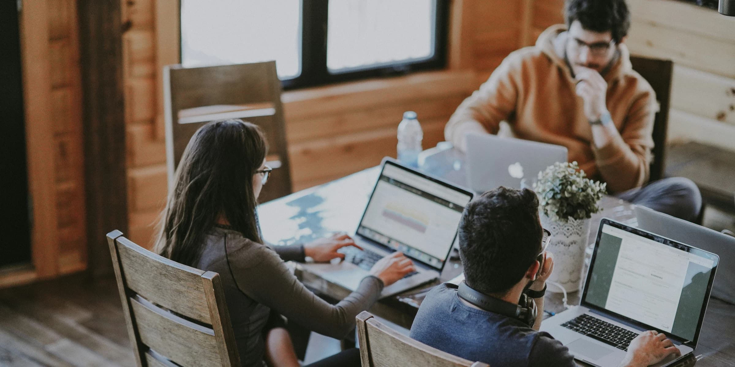 Team werkt samen aan laptops rond één werktafel